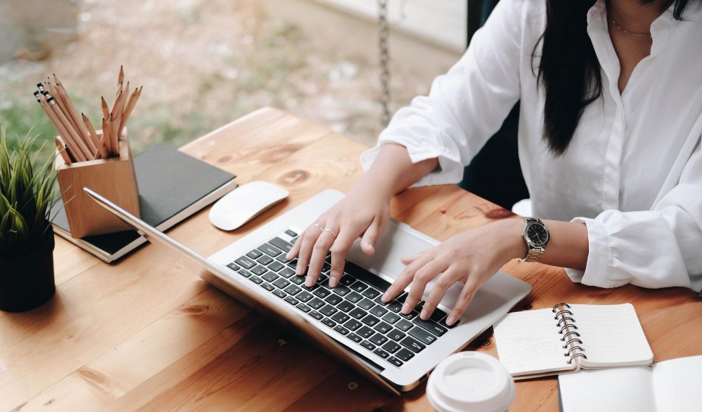 Mulher empoderada trabalhando no seu laptop em casa, explorando maneiras de ganhar dinheiro na internet